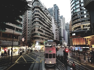 A bustling city street with colorful trams and people walking along the sidewalks.