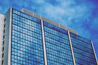 blue and white glass walled building under blue sky