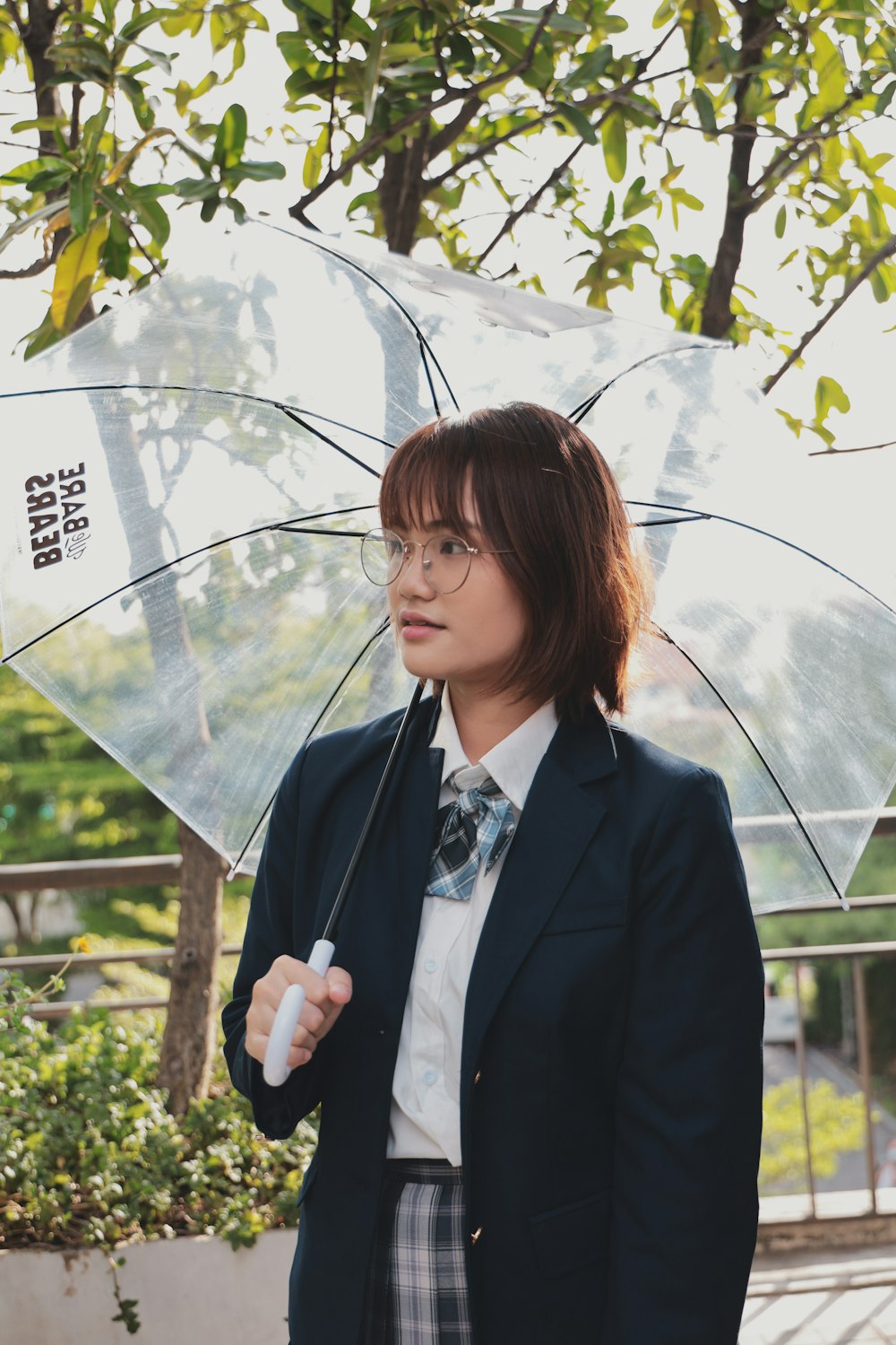 woman in black blazer holding umbrella