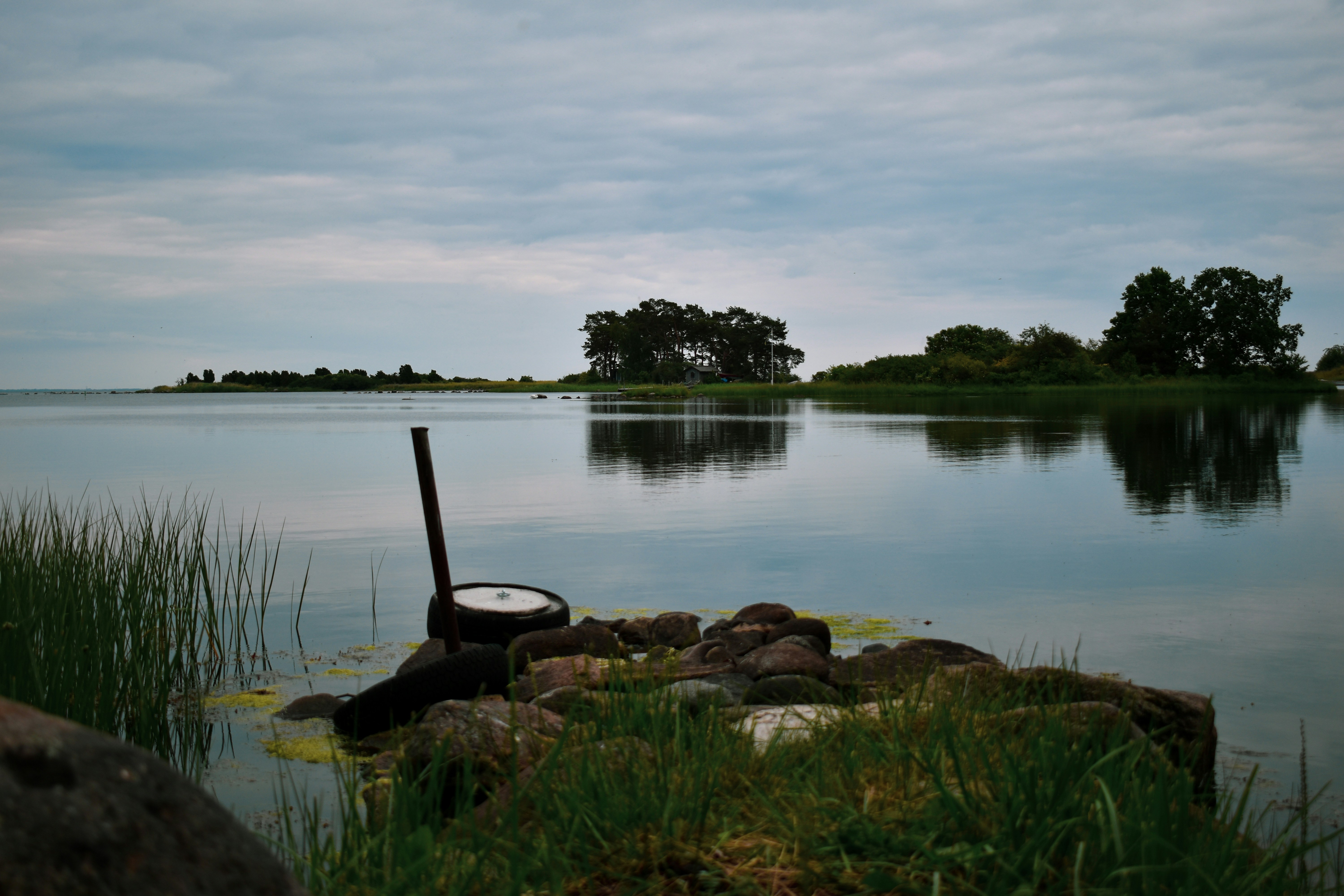 brown rocks on lake under white sky during daytime