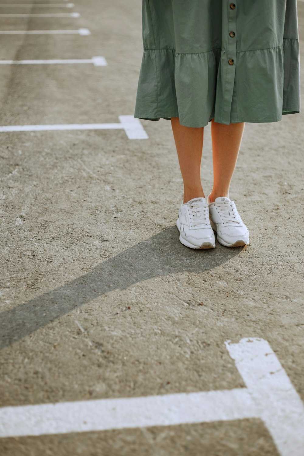 woman in green skirt and white sneakers