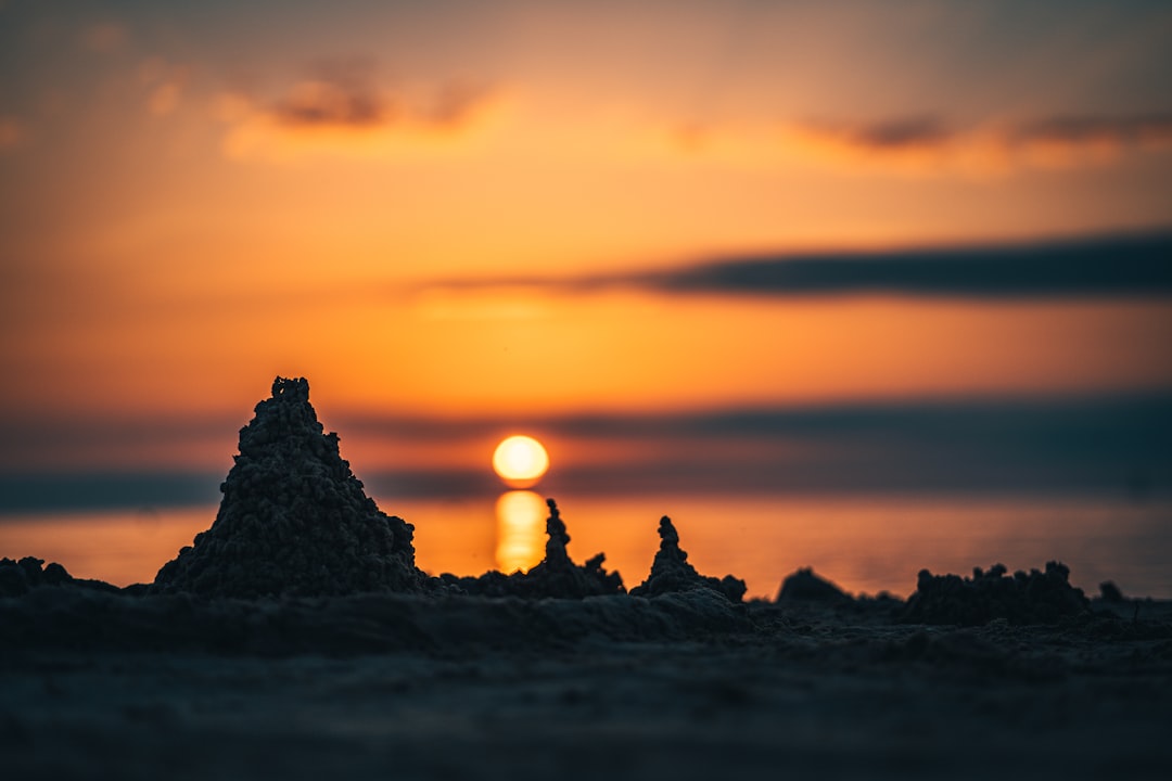 silhouette of people on rock formation during sunset