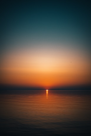 body of water during sunset