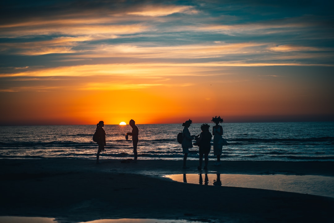 silhouette of people on beach during sunset