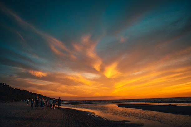 A group of travelers walking through a stunning coastal circuit at sunset.
