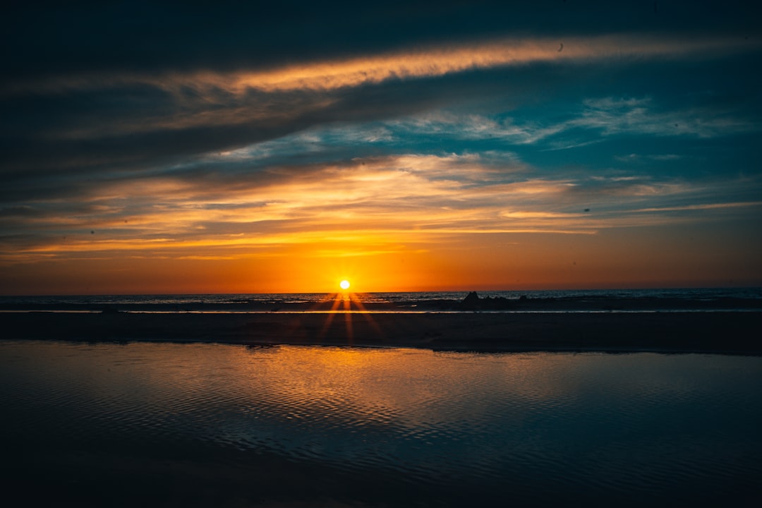 body of water under blue sky during sunset