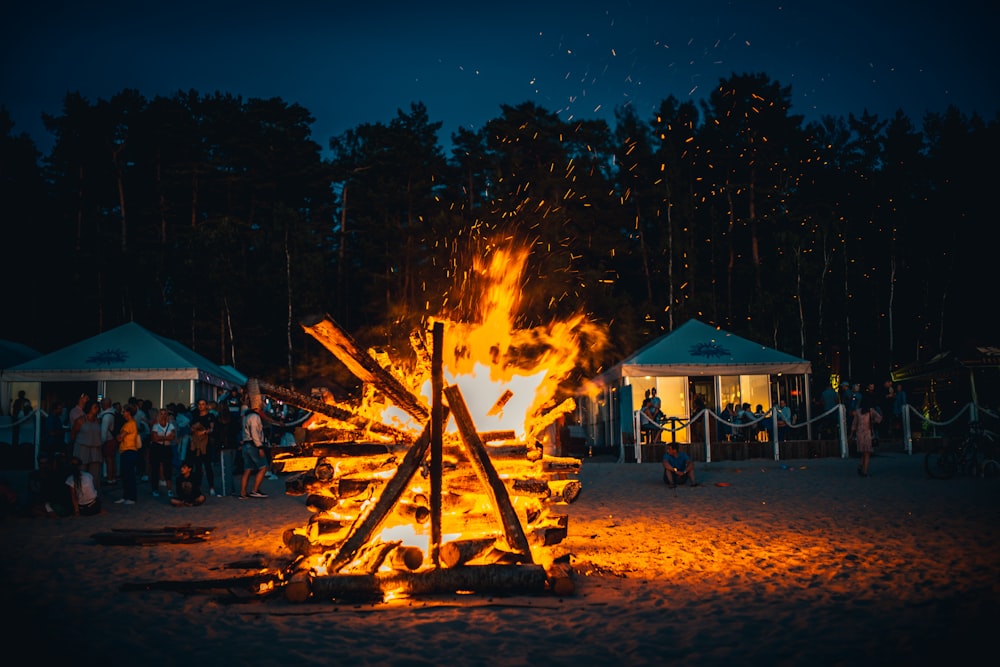 bonfire near white and brown wooden house during night time