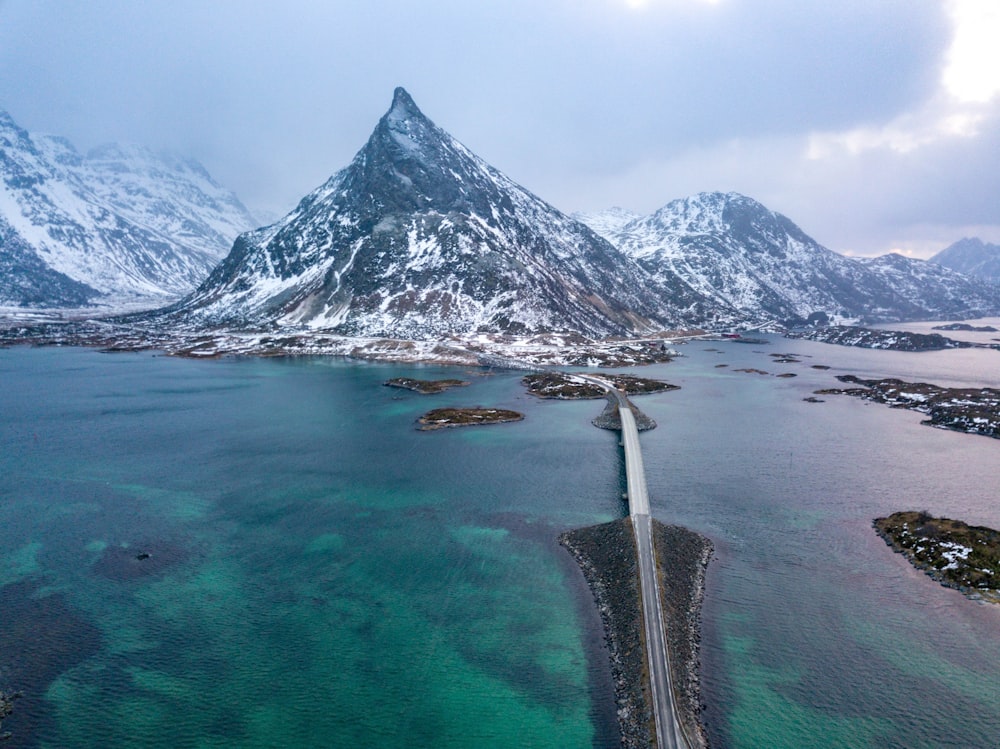 gray concrete road near snow covered mountain during daytime