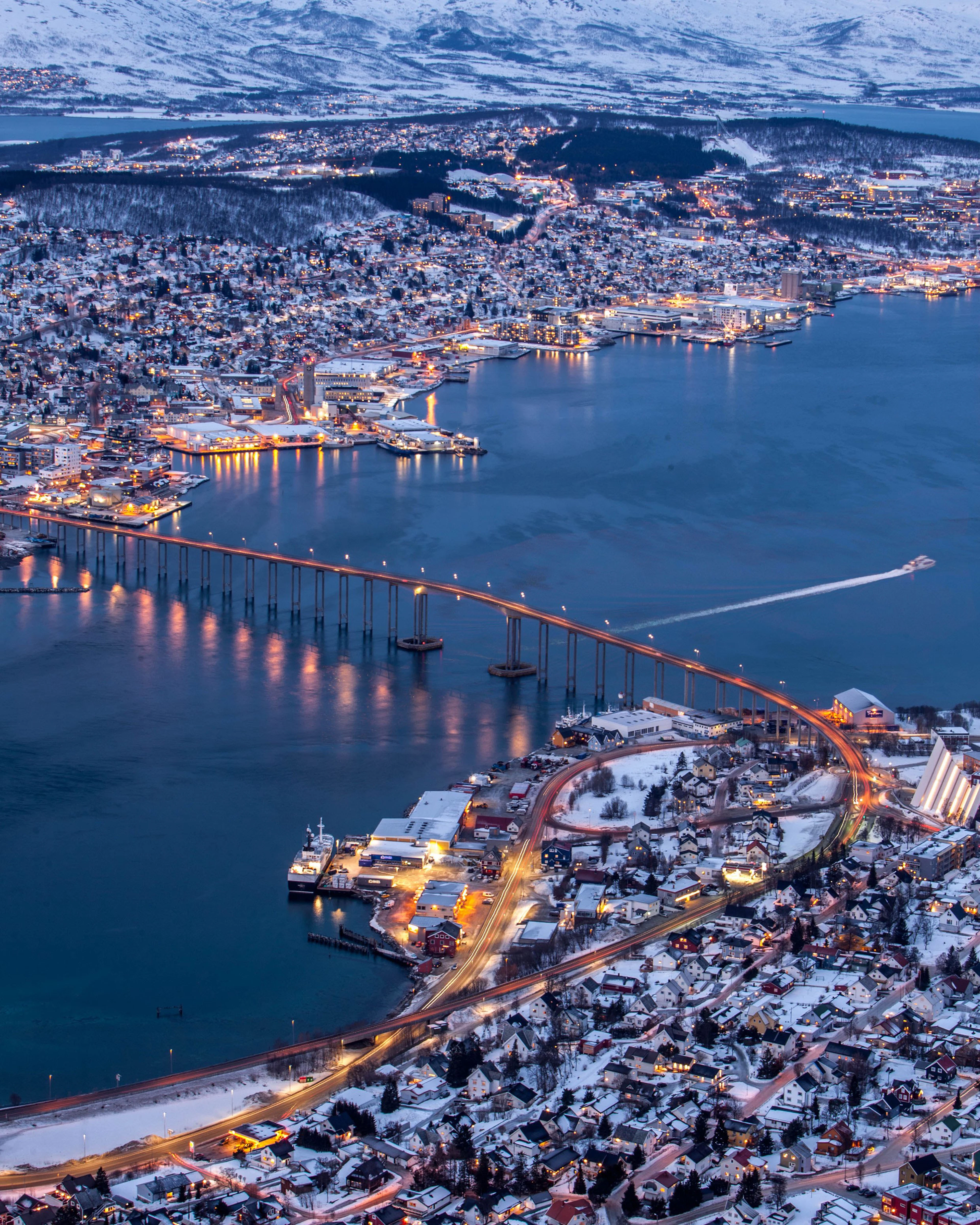 Tromsø and its lit bridge across the sound in the blue winter twilight, seen from Fjellheisen