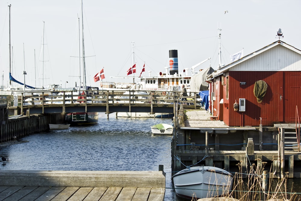 weißes und rotes Boot tagsüber am Dock