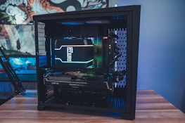 A small business owner happily working on a custom-built PC surrounded by peripherals.