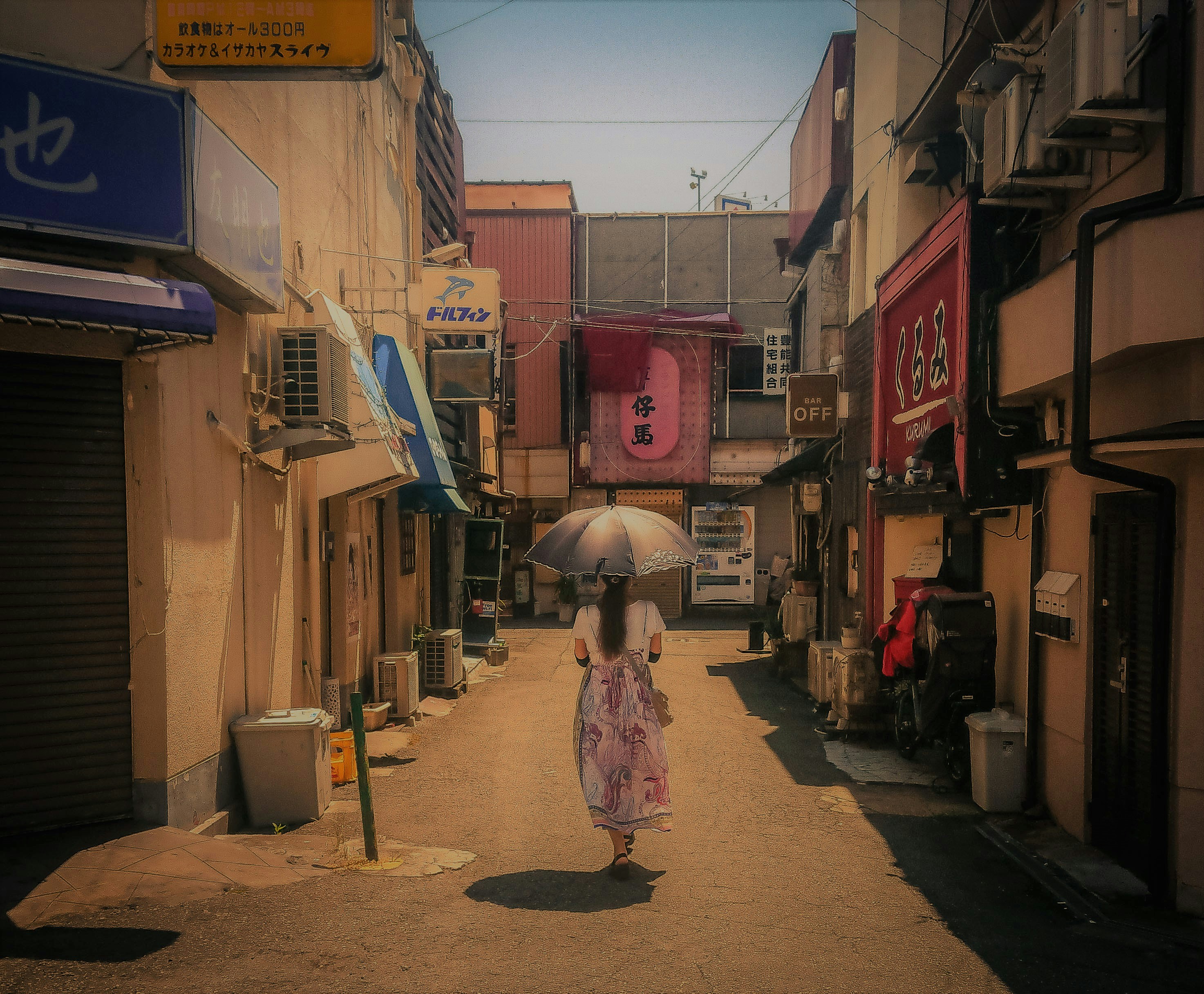 Mujer en vestido rosa sosteniendo paraguas caminando en la acera durante el día