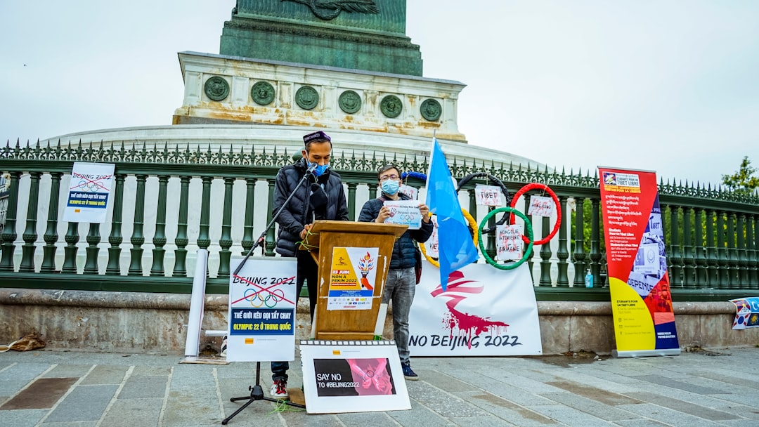 man in black jacket holding white and red banner