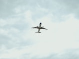blue airplane flying in the sky during daytime