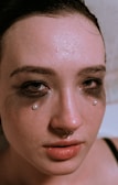 A model with a septum piercing and elegant makeup.