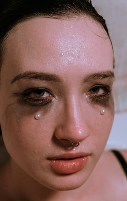 A model with a septum piercing and elegant makeup.