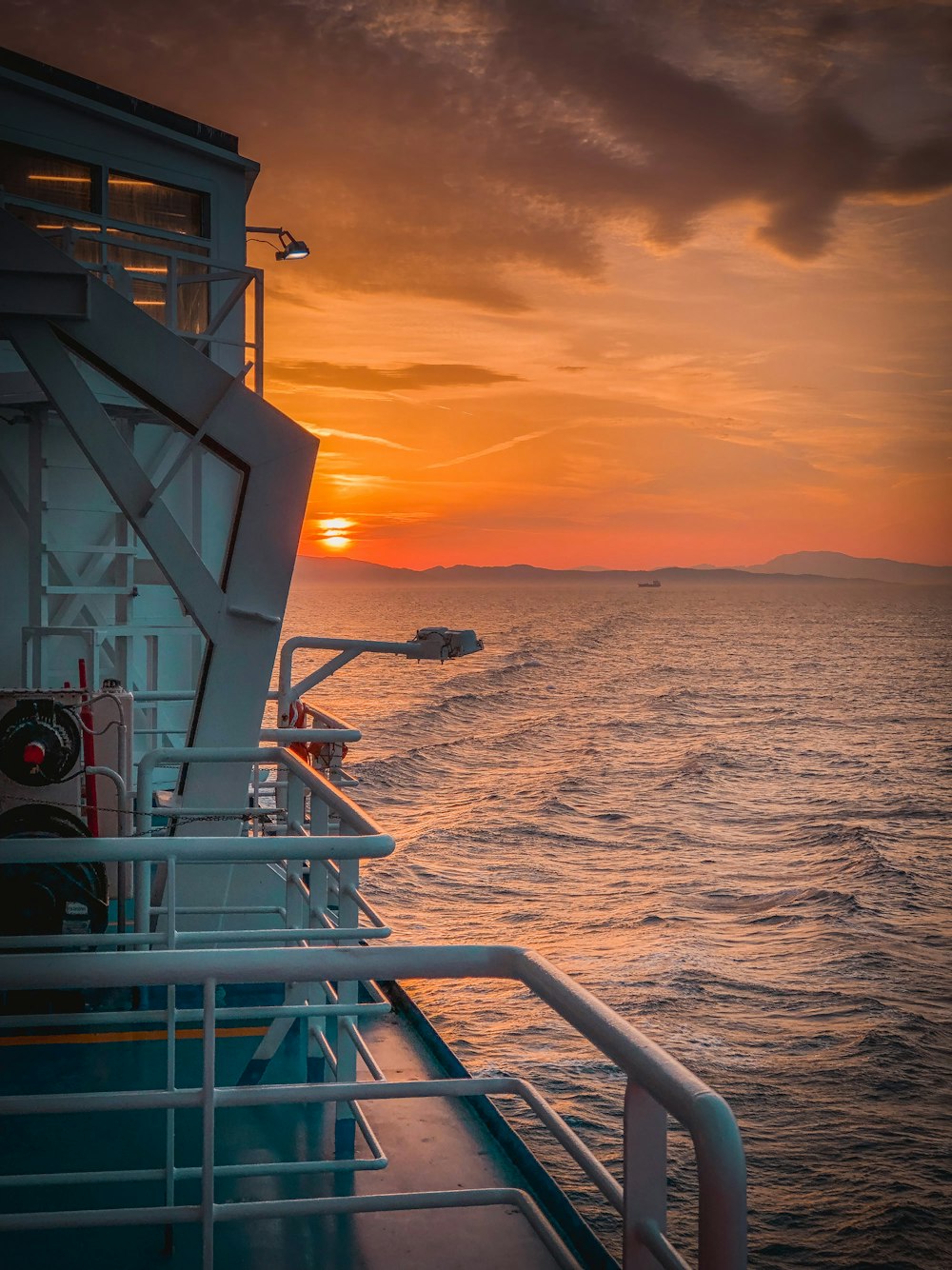 the sun is setting over the ocean on a boat