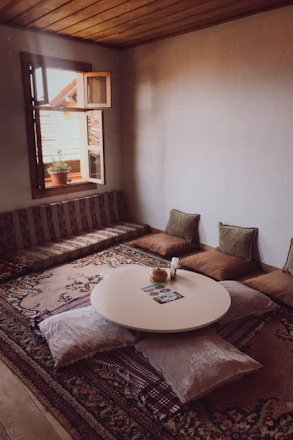 A warm, inviting room with soft natural light, cushions, and plants creating a peaceful atmosphere.