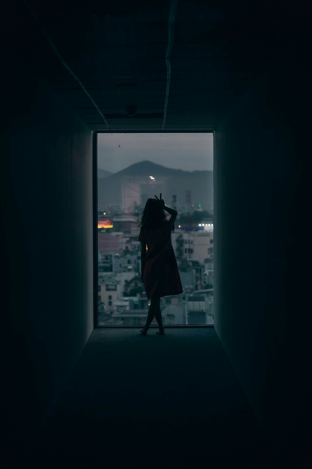 silhouette of woman standing in front of glass window