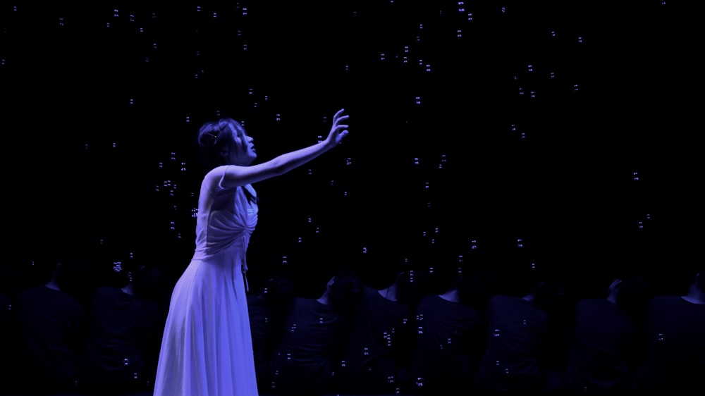 woman in white dress standing on stage