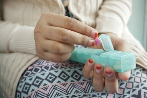 person holding white and green plastic container