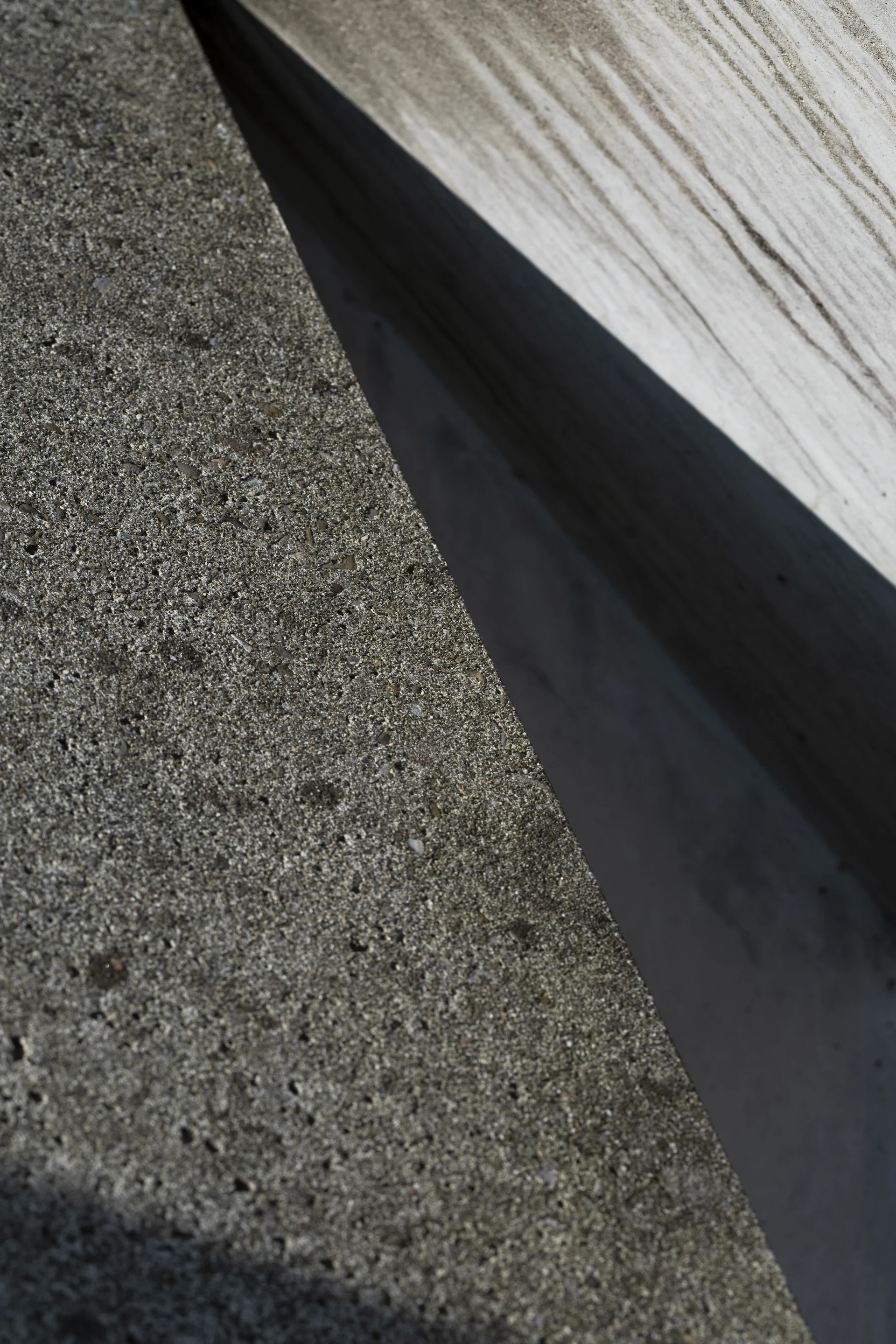 A close-up diagonal view of freshly poured, textured concrete.