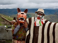 a couple of people with animal masks standing next to each other