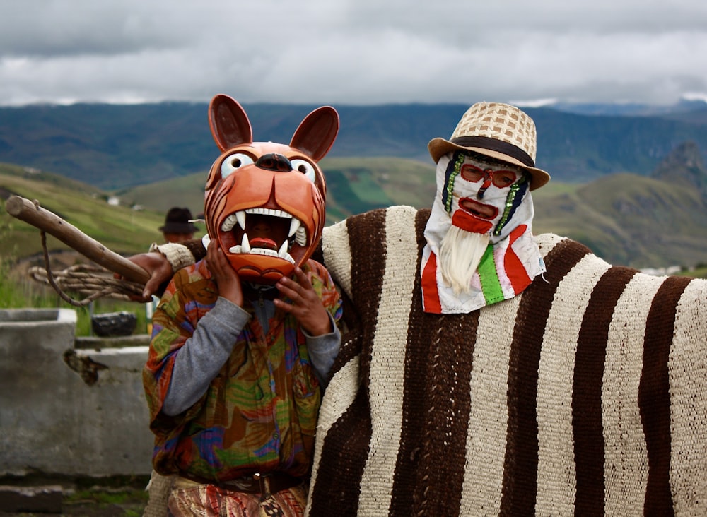 Un par de personas con máscaras de animales de pie una al lado de la otra