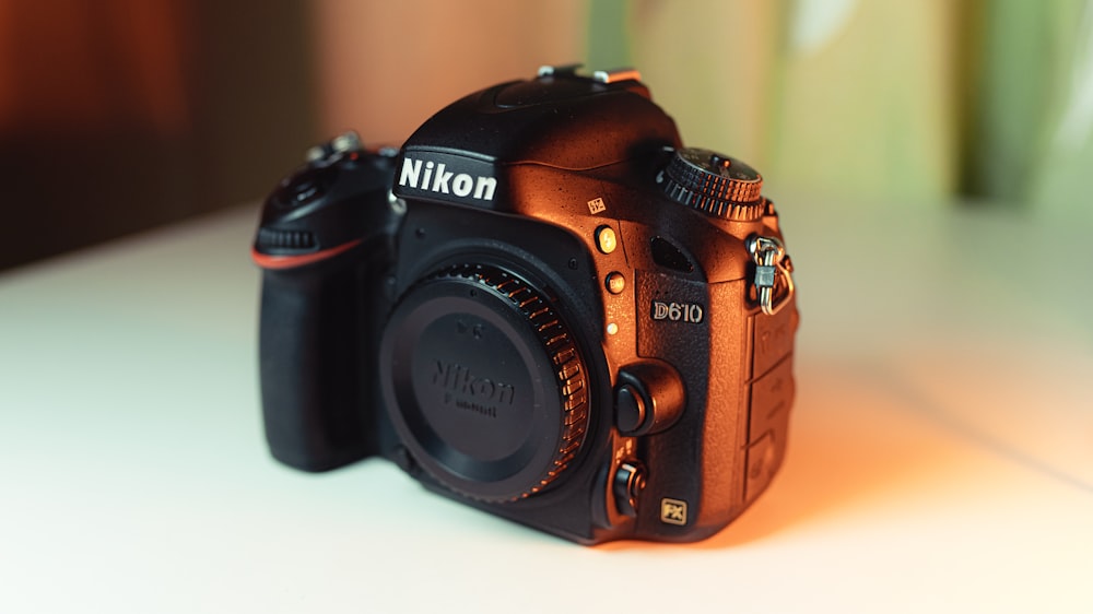 black nikon dslr camera on white table