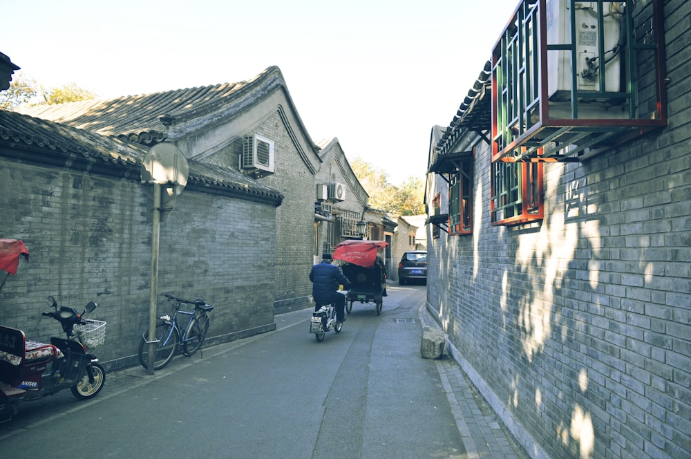 black and red stroller beside gray concrete building during daytime