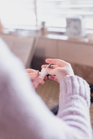 Smiling adult using mounjaslim spray in a bright, cozy living room setting.
