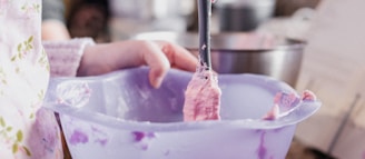 person holding stainless steel spoon and clear glass bowl