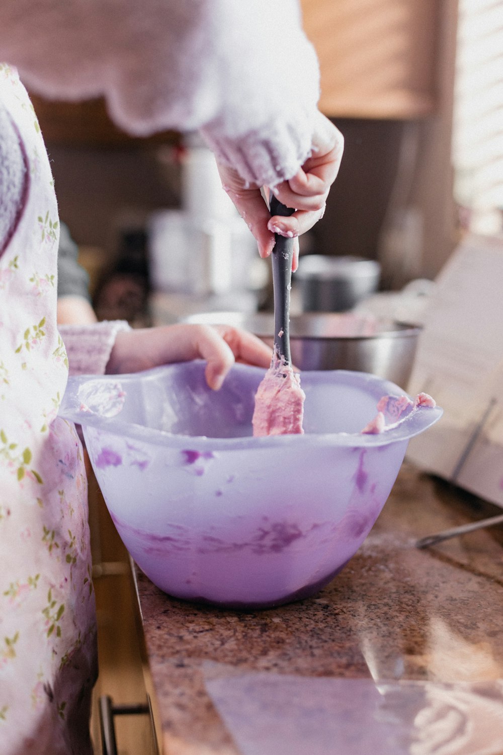 person holding stainless steel spoon and clear glass bowl