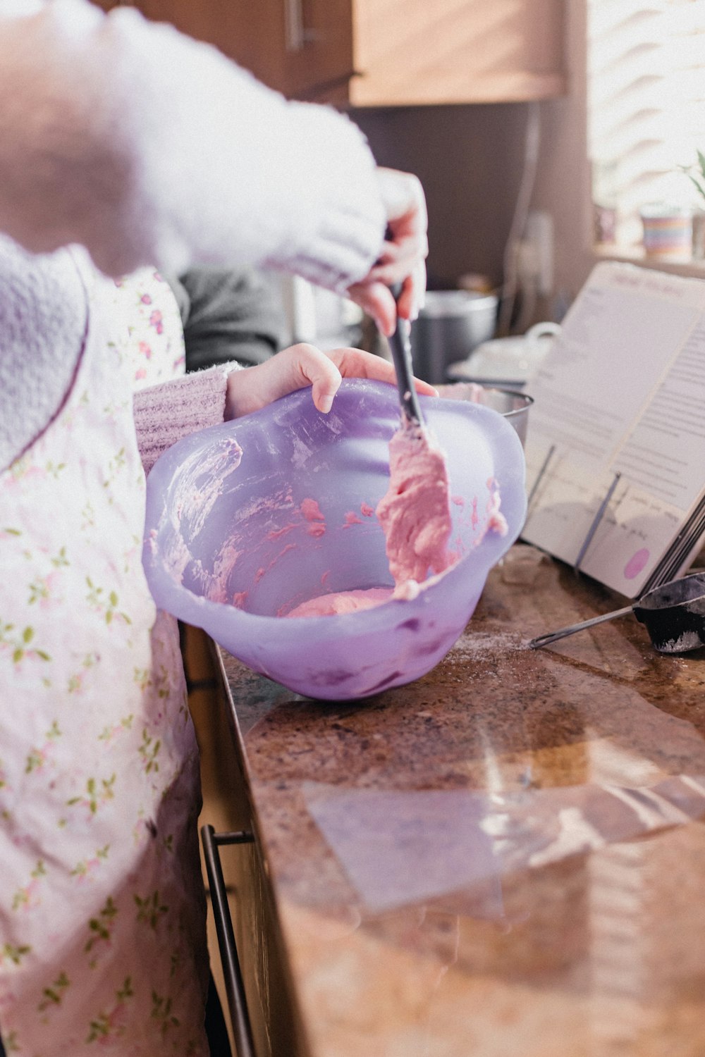 person holding black pen and pink plastic bowl