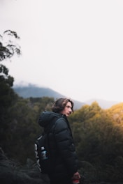 woman in black jacket standing on mountain during daytime