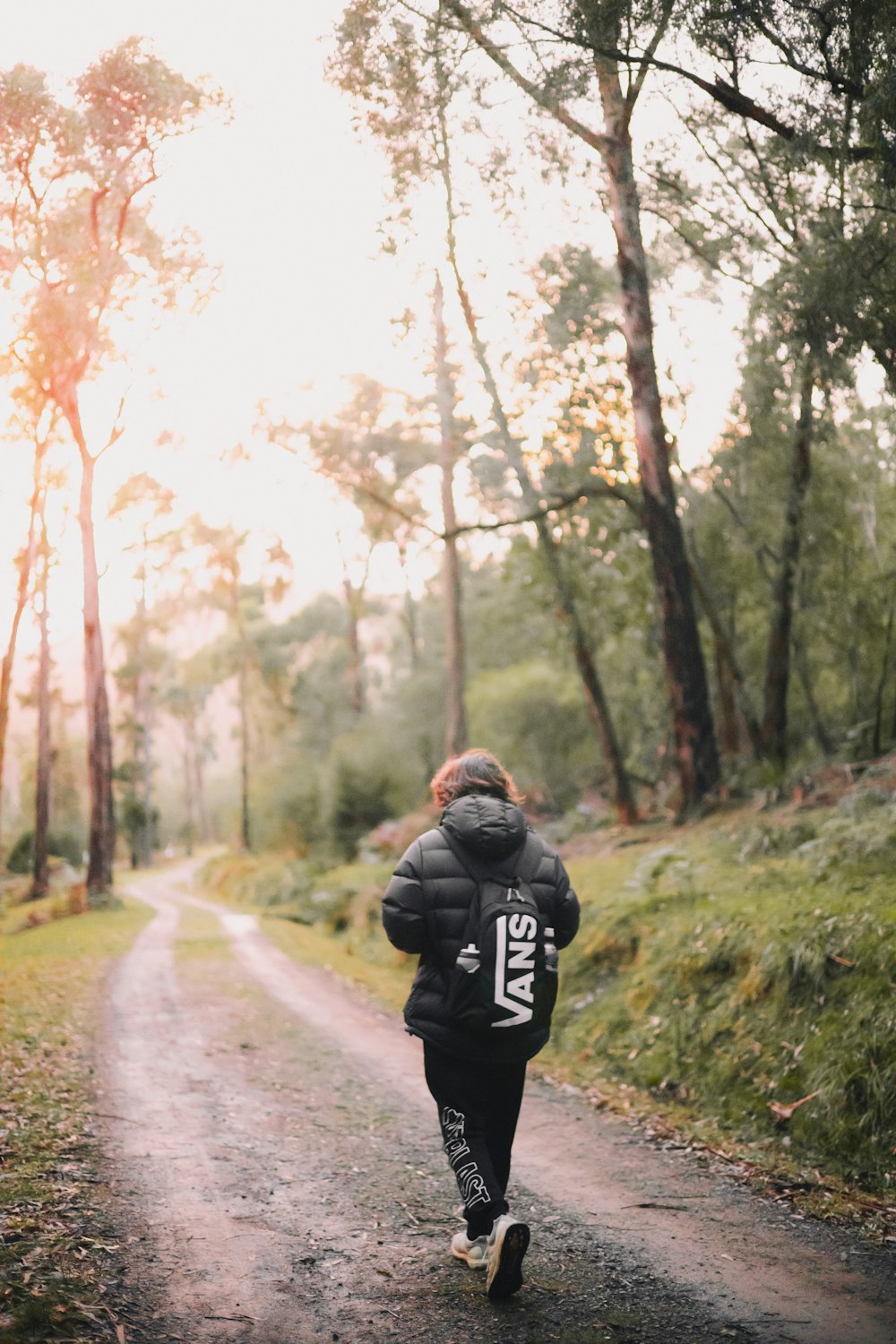 man in black jacket walking on road during daytime