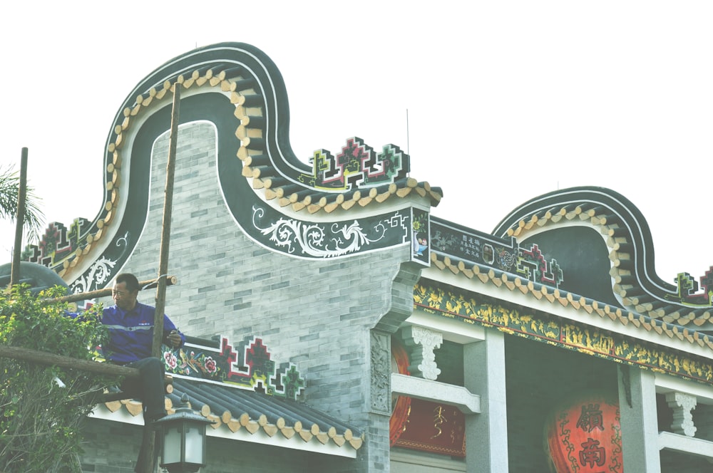 a man standing on top of a metal railing next to a building