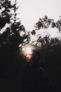 Low-light shot of a person wearing Noxvigil gear navigating through a misty urban forest at dusk.