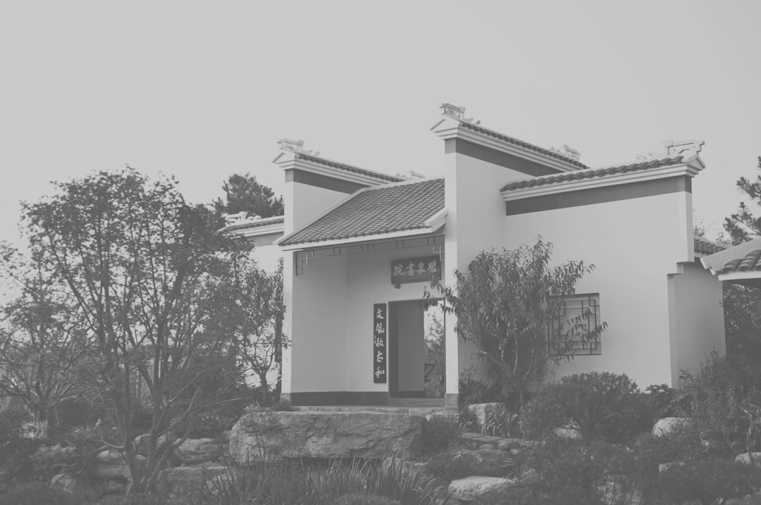 white concrete house near trees during daytime