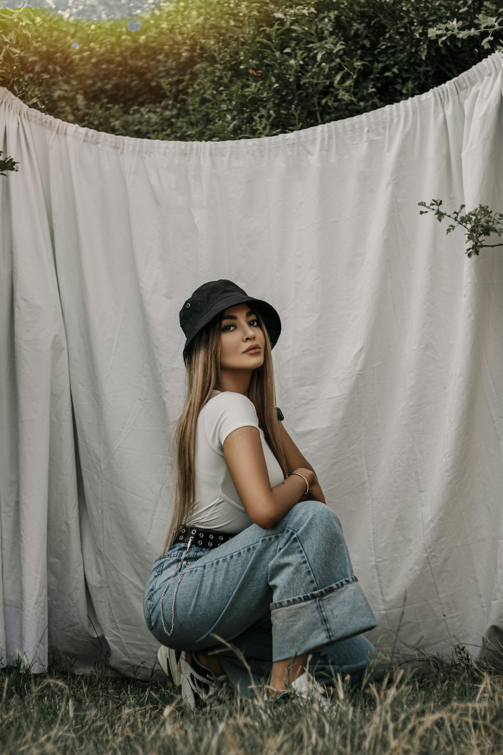 woman in white tank top and blue denim jeans wearing black hat