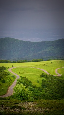 A scenic view of a winding road through lush green hills.