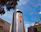 Close-up of a clean, modern metal waste container with company branding in an urban setting.
