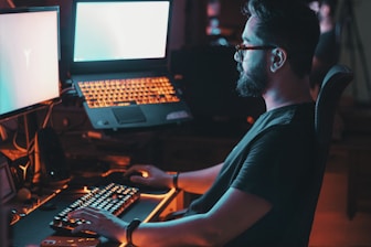 man in blue shirt using computer