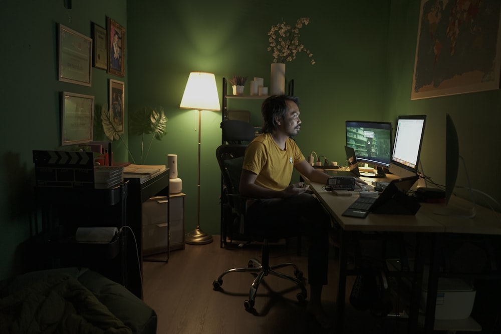 man in yellow polo shirt sitting on black office rolling chair