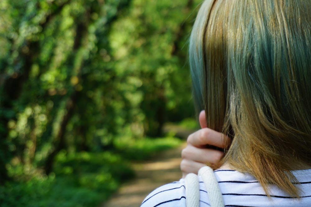 woman in white sweater covering her face with her hand