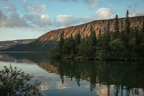 Forested hills reflected in a lake — Murmansk, Russia