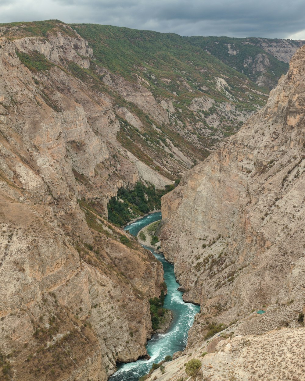 fiume tra le montagne rocciose marroni durante il giorno