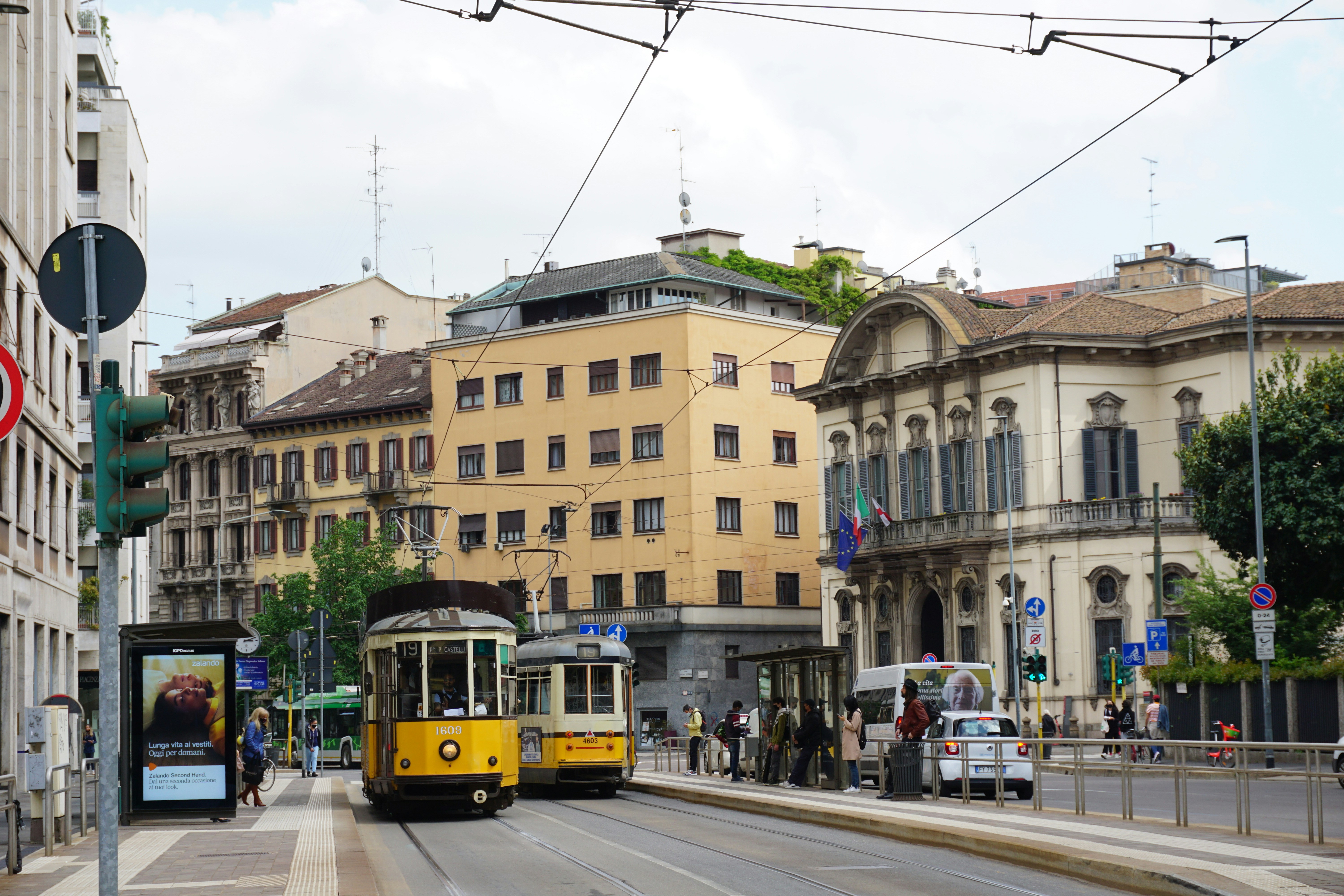 yellow and black tram on road near brown concrete building during daytime