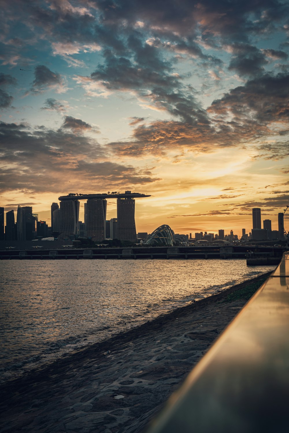 bridge over water near city skyline during sunset