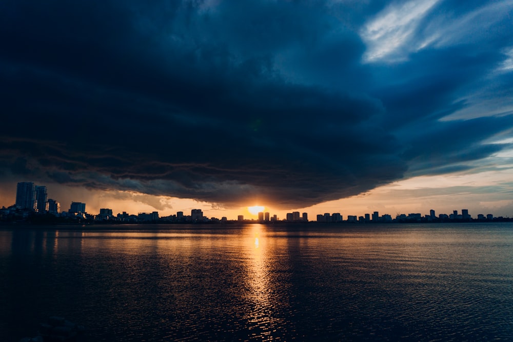 city skyline across body of water during night time